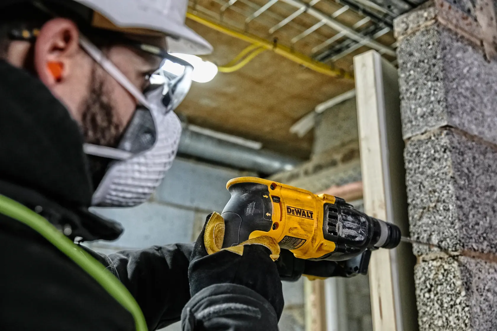 Eine kabelgebundene DEWALT D25133K Schlagbohrmaschine mit schwarzem und gelbem Design, seitlichem Griff und Tiefenanschlag.