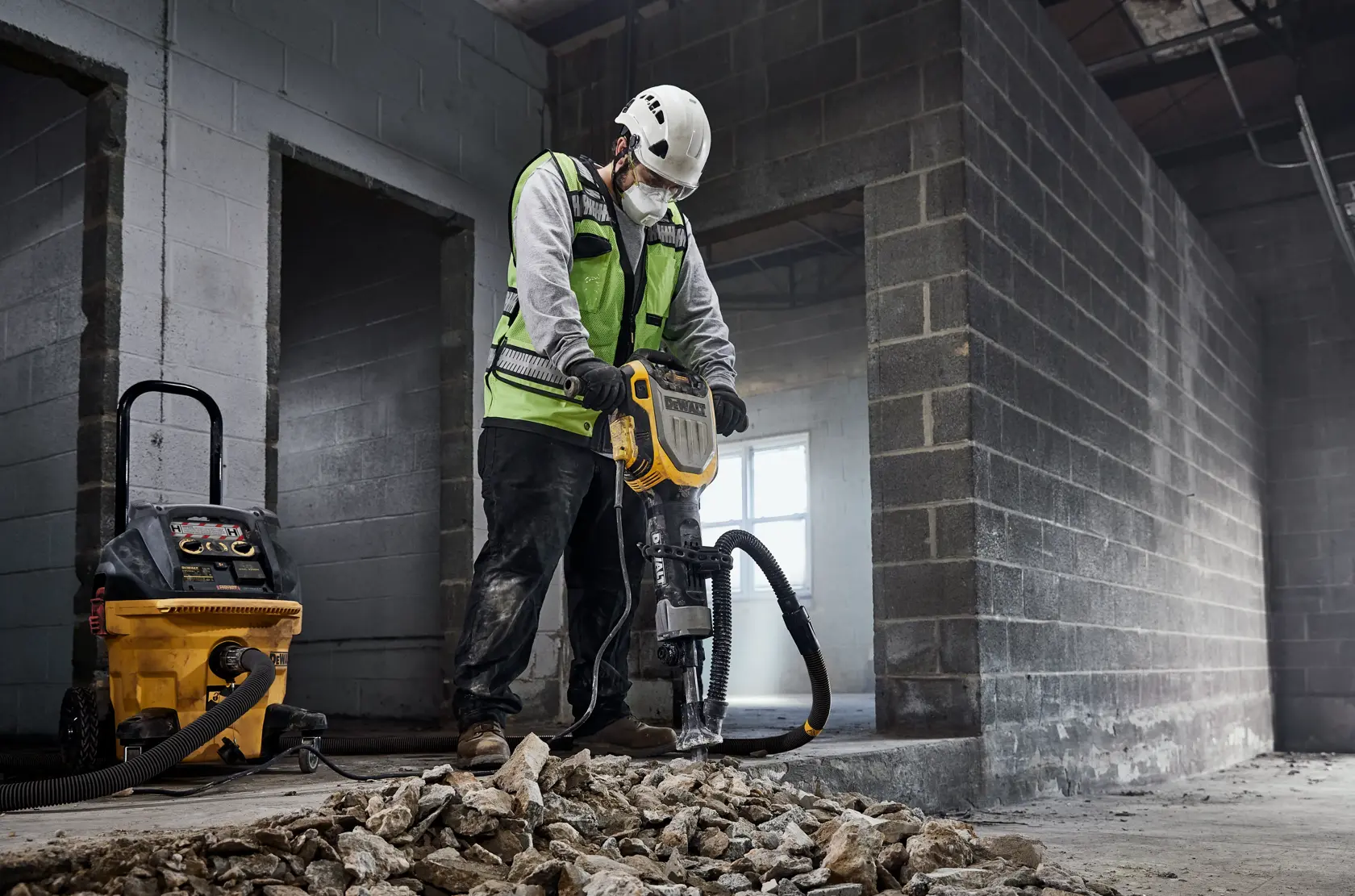 Arbeiter nutzt DEWALT D25966, D25966-B2 Abbruchwerkzeug auf Trümmern. Baustelle.