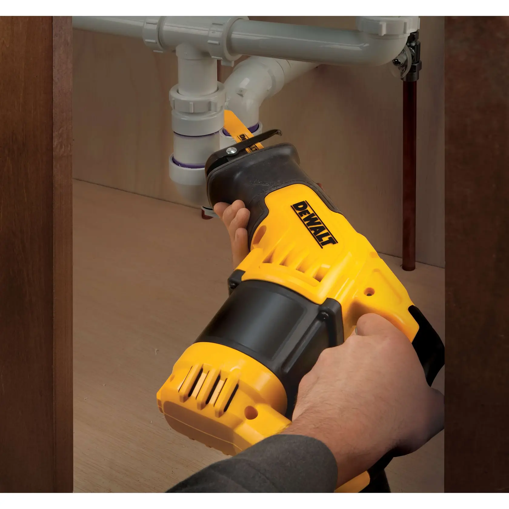 Sierra recíproca DEWALT utilizada bajo un fregadero para cortar tuberías.