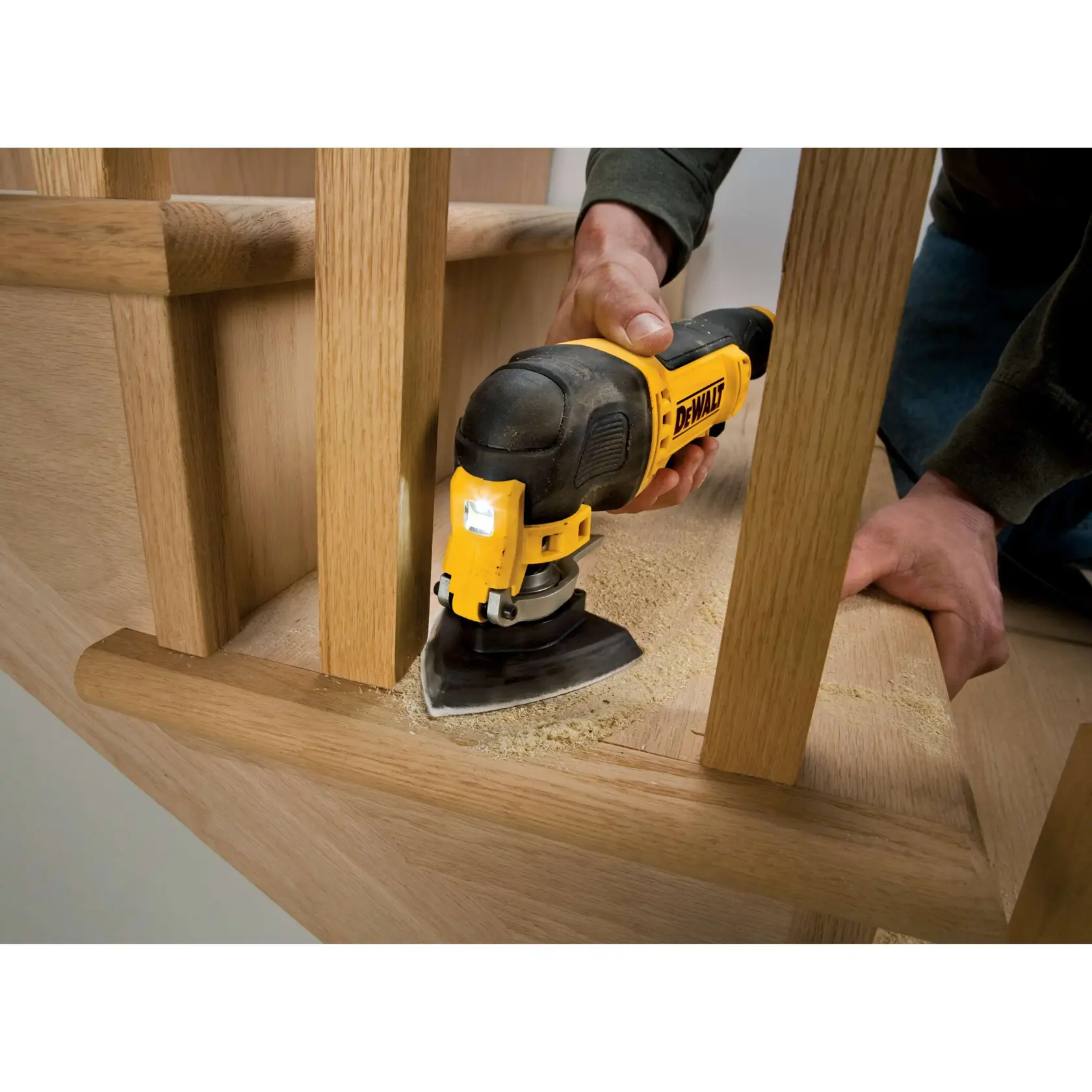 Lijadora DEWALT utilizada para lijar escalera de madera en una esquina estrecha.