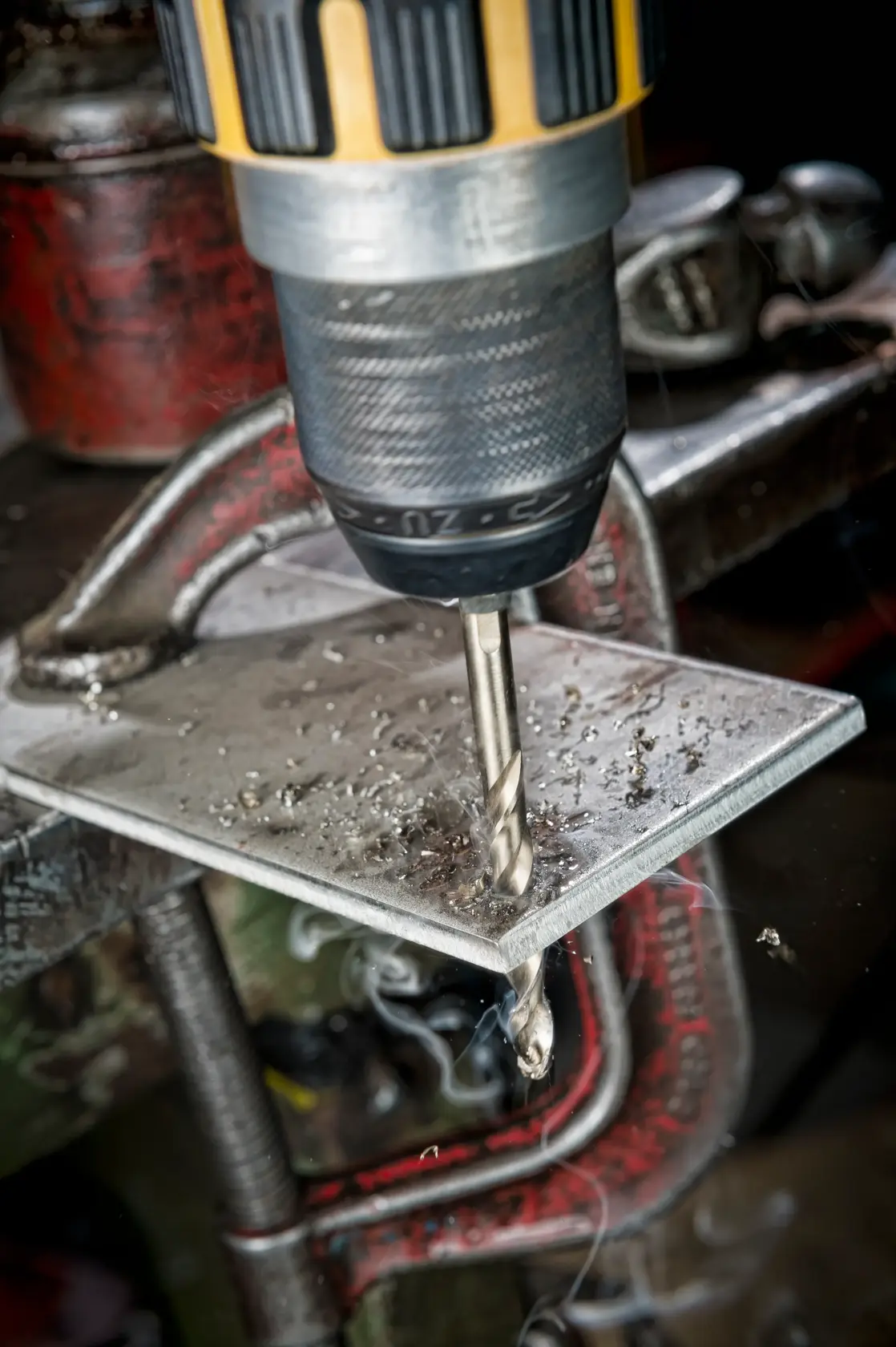 DEWALT DT4934-Bohrer bohrt in eine befestigte Metallplatte, erzeugt Metallspäne.