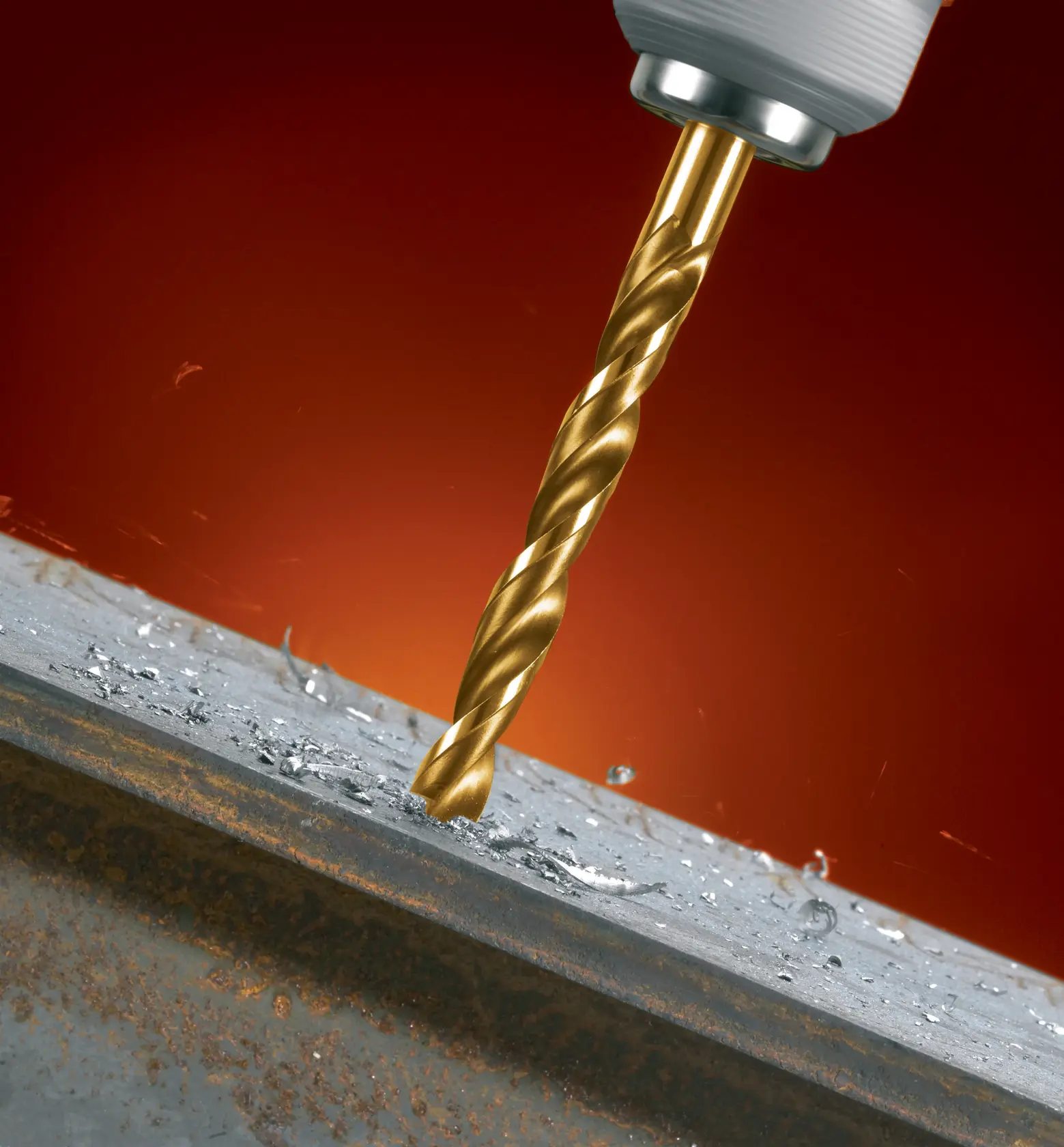Goldener DEWALT-Bohrer durchdringt Metall, Metallspäne, Nahaufnahme, orange Hintergrund.