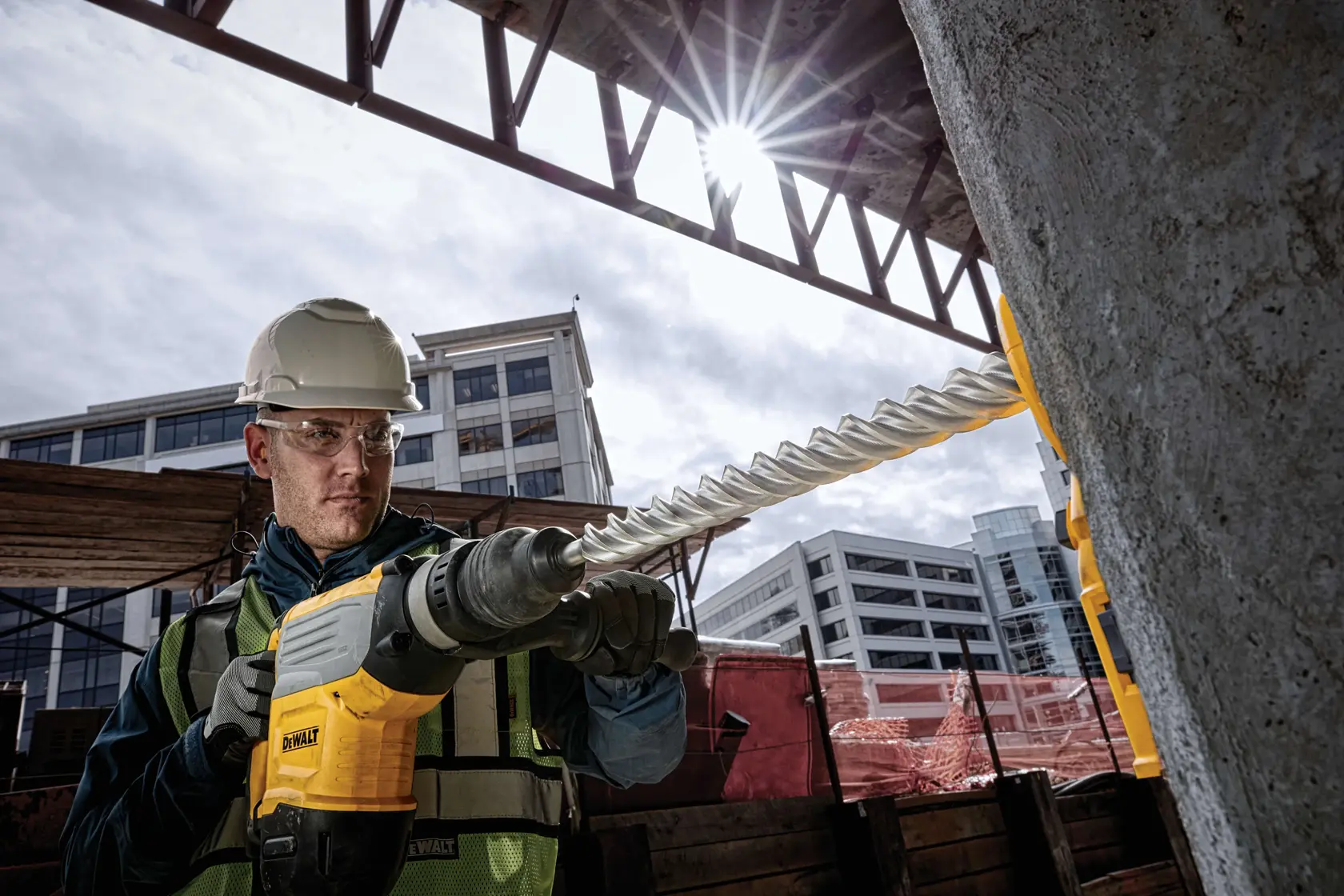 DEWALT DT60825-Bohrer im Einsatz auf Baustelle, Arbeiter mit Sicherheitsausrüstung bohrt Beton.