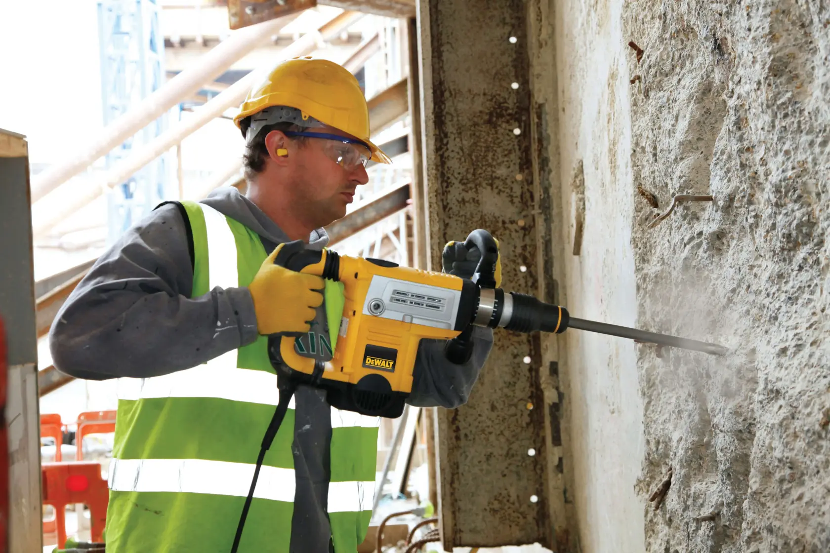 DEWALT DT8087, DT8087-QZ Bohrhammer an Betonwand auf Baustelle. Produktkategorie: Fotografie.