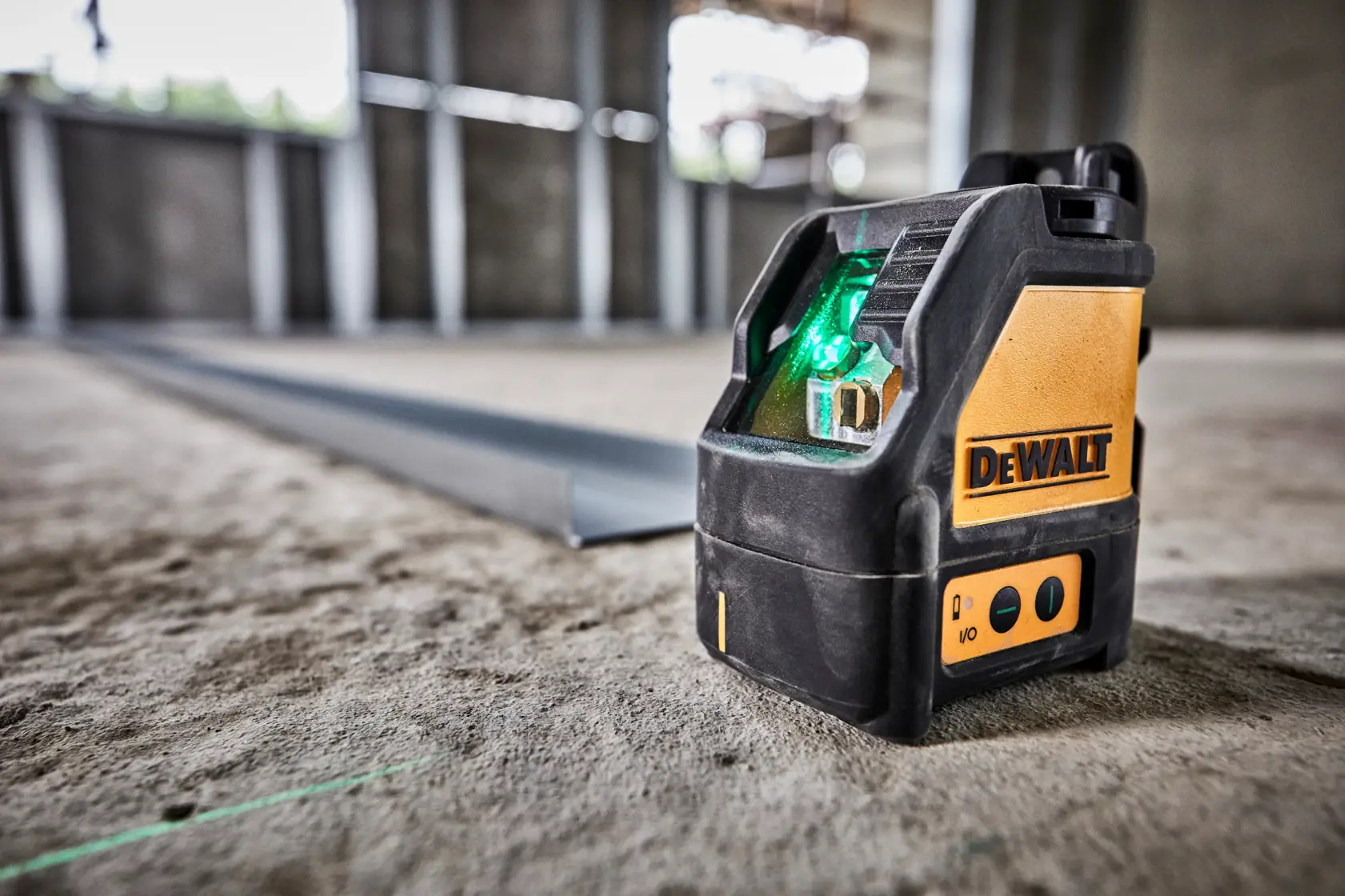 DEWALT grüner Laser DW088CG auf Betonboden einer Baustelle.