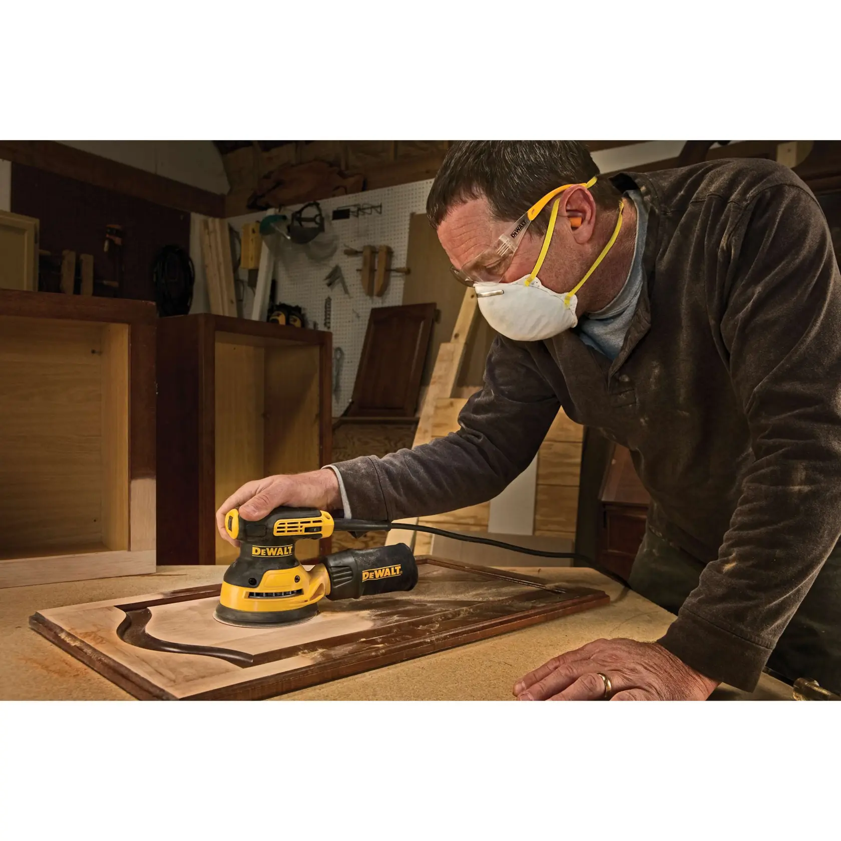 Ein elektrischer DEWALT-Schleifer mit Staubauffangbeutel, dargestellt in Schwarz und Gelb, darunter steht der Text „REDUZIERTE VIBRATION MIT SEPARATEM GEGENGEWICHT".