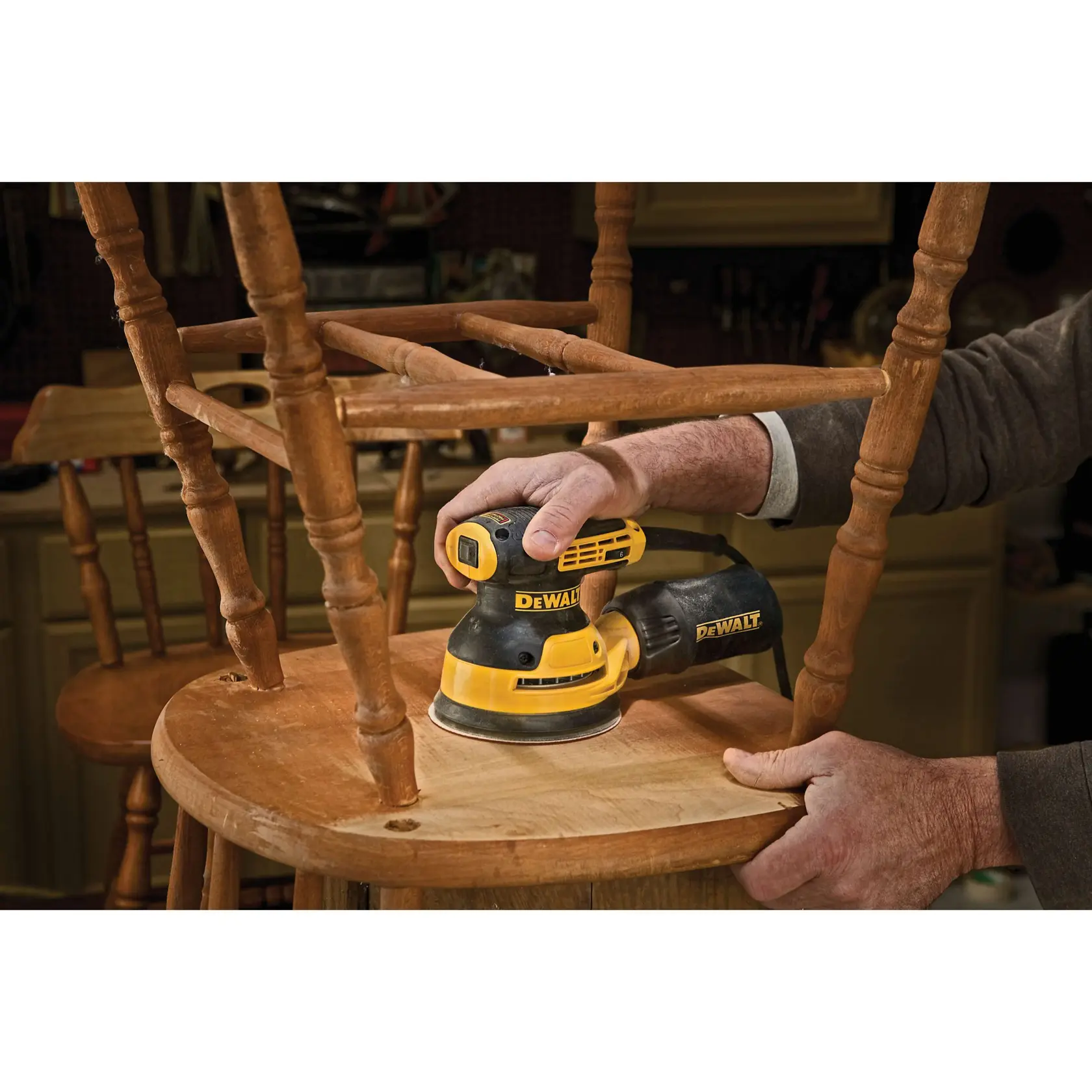 Ein DEWALT DWE6423 Exzenterschleifer wird mit markierten Produkteigenschaften gezeigt. Der Schleifer ist gelb und schwarz, mit einem staubgeschützten Schalter, separatem Gegengewicht und einem Staubanschluss mit Staubbeutel.