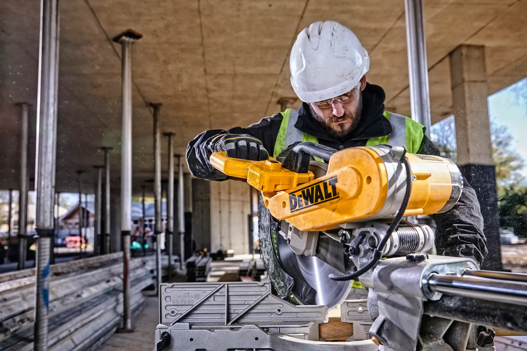 DEWALT DWS780, DWS780KIT Säge auf Baustelle, Arbeiter mit Helm und Weste. Kategorie Fotografie.